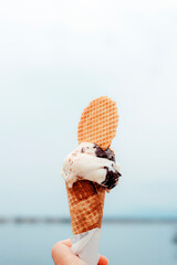Tasty ice cream in hand on the background the sea