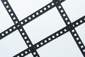 black paper stripes with square holes on white paper