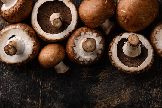 Raw champignon mushrooms on black background