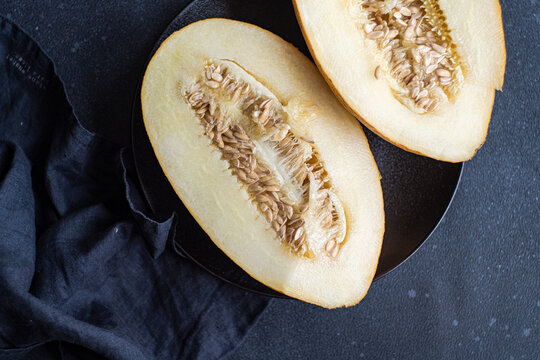 Slices of sweet ripped melon served on concrete black table