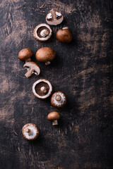 Raw champignon mushrooms on black background