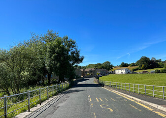 Ribble Lane, with metal railings, old trees, and distant houses in, Grindleton, UK