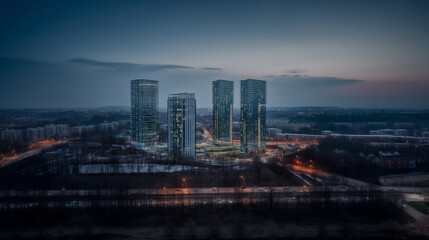 Fototapeta premium Modern city. Evening illumination. High buildings. Beautiful sky. Interesting city architecture