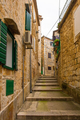Fototapeta na wymiar A street of historic stone houses in Milna Village on the west coast of Brac Island in Croatia. Some of the doors are filled in or boarded up