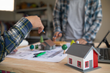 Architects and engineers discuss how to design  housing estate to ensure construction is up to standard and completed on time. team of engineers and architects discuss building design and structure.