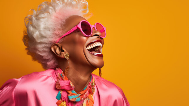 Happy and playful mature woman in stylish outfit on orange background.