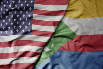 big waving colorful flag of united states of america and national flag of comoros .