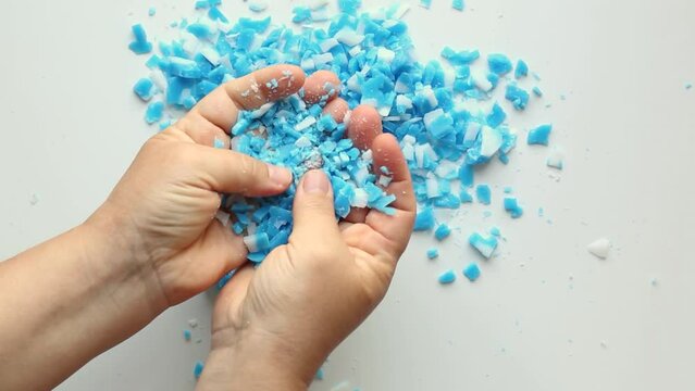 A person's hands scatter, sort out blue, white slices. Asmr.