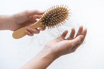 Serious asian young woman, girl hand in holding comb, show her hairbrush with long loss, loose hair problem after brushing, hair fall out problem. Health care, beauty with copy space on background.