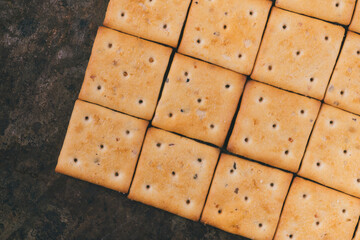 Spicy square crackers on the baking tray. Top view.