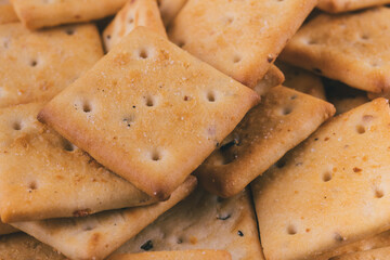 Heap of delicious spicy square crackers. Salty crackers closeup. Macro shot. Selective focus.