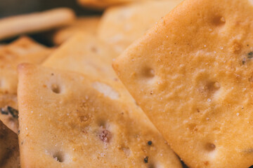 Heap of delicious spicy square crackers. Salty crackers closeup. Macro shot. Selective focus.