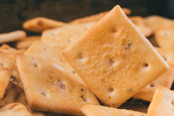 Heap of delicious spicy square crackers. Salty crackers closeup. Macro shot. Selective focus.