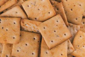 Heap of delicious spicy square crackers. Salty crackers closeup. Macro shot. Selective focus.