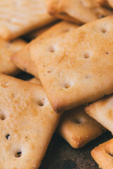 Heap of delicious spicy square crackers. Salty crackers closeup. Macro shot. Selective focus.