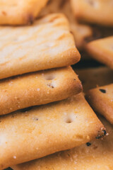 Heap of delicious spicy square crackers. Salty crackers closeup. Macro shot. Selective focus.
