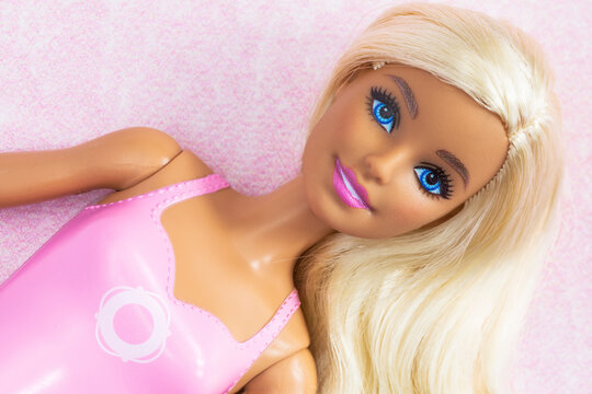 A beautiful stylish plastic barbie doll Barbie body part, Toy for children, playful glamour girl barbie toy portrait. Barbie doll on pink background Barbie logo