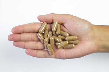 Ashwagandha pills held in hand on white background, medical support of the body