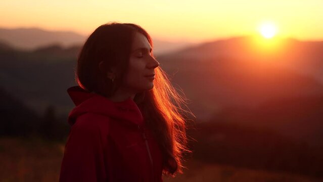 Portrait of calm woman hiker looking ahead and exhaling fresh air taking deep breath and reducing stress during hiking in the mountains Serene female resting for peaceful mind outdoors