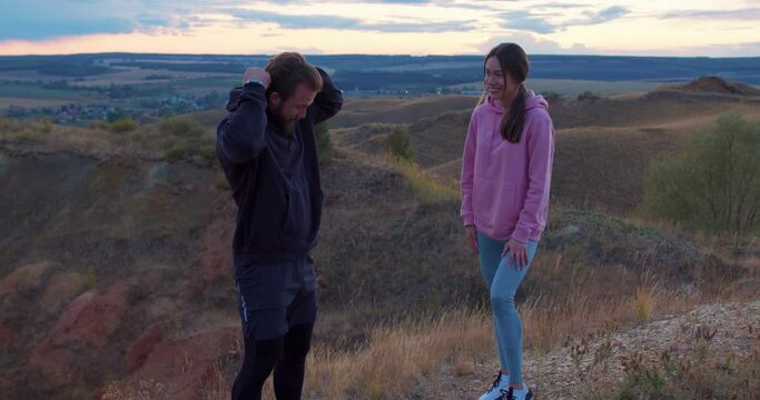 couple standing on hill, strat jogging on unusual place, family working out on mountains, woman and man lead healthy lifestyle , athlete in hoodie preparing for competition, race Slow motion