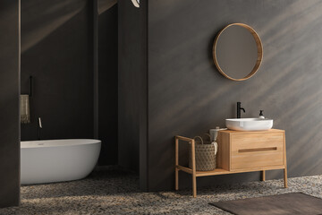 Black minimalist bathroom interior with wooden vanity, bathtub, terrazzo floor.