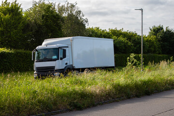 White rigid lorry with white box trailer travelling on the dual carriageway.