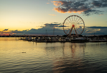 Illuminated ferris wheel at National Harbor near the nation capital of Washington DC at sunset with...