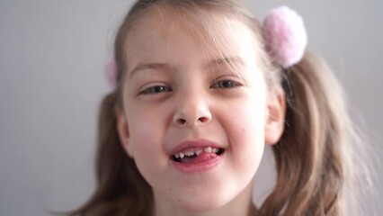 Charming smiling little girl kid with opened mouth shows staggering loose falling out first baby milk front tooth. Preschooler teeth changing. Healthy dental hygiene. Lost tooth. Dentist treatment