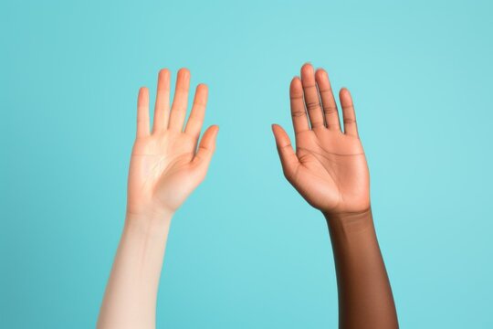Two raised hands, a white and a black hand. Isolated on a plain blue colored background. Generative AI.