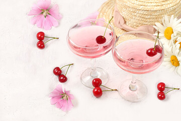 Summer trendy banner on bright background.Straw hat,fruits in eco bag,refreshing alcoholic drinks and chamomile flowers on sunny table.Vacation and travel concept,outdoor camping