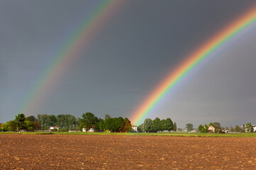 Colorful rainbow against the background of a dangerous, stormy sky