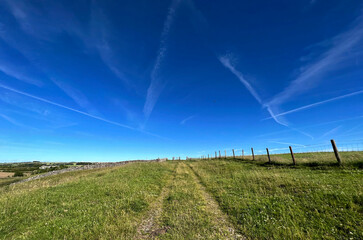 High on the hill top, with a cart track, dry stone walls, and fields, set against a vivid blue sky...