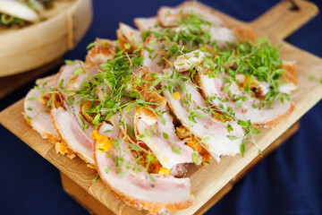 Sliced chicken on chopping board with greens