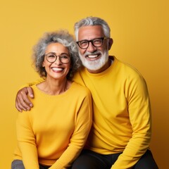 Happy old couple on yellow background.
