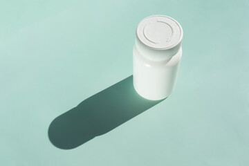 Top View White Bottle Of Medication Pills Or Vitamins On Green , Mint Background With Shadow....