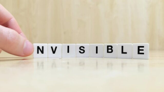 Tiles that make up the word invisible are modified to make up the word visible