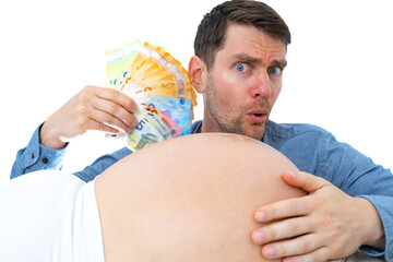 Expectant father behind pregnant baby bump waves a stack of banknotes wind in his face and looks worried. Last month of pregnancy - week 39. White background. Bright shot.
