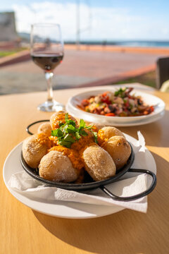 Canary Islands dish Papas Arrugadas wrinkly salty potatoes with and Mojo picon red spicy sauce.