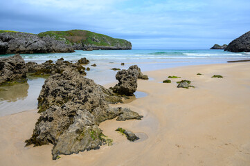 View on Playa de Borizo in Celorio, Green coast of Asturias, North Spain with sandy beaches, cliffs, hidden caves, green fields and mountains.