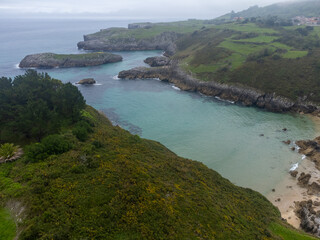 Obraz premium Aerial view on Playa de Toro in Llanes, Green coast of Asturias, North Spain with sandy beaches, cliffs, hidden caves, green fields and mountains.