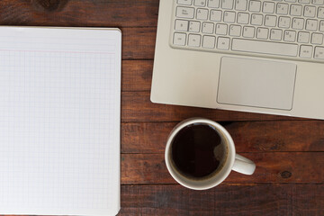 Obraz na płótnie Canvas Coffee cup, laptop, and notebook on a desk, back to shcool, business