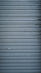 Obraz premium Vertically long old and worn metal shutter door texture