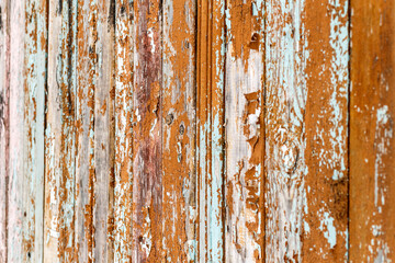 Old brown cracked paint on a wooden fence. Volumetric roughness of an old wooden wall. The beauty of old buildings.