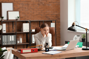 Tired female accountant working at table in office - obrazy, fototapety, plakaty