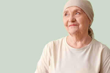 Senior woman after chemotherapy on green background