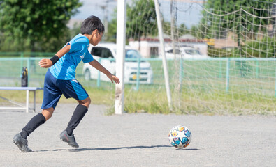 サッカーの練習をする小学生の男の子