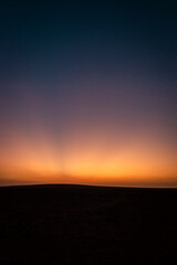 Fototapeta na wymiar Desert Solitude: Vibrant Sunset in High Contrast