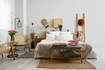 Fototapeta na wymiar Interior of stylish bedroom with cozy bed and bedside bench