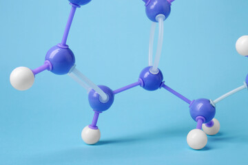 Molecule of phenylalanine on light blue background, closeup. Chemical model