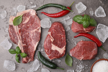 Flat lay composition with cut fresh beef meat on brown table, flat lay